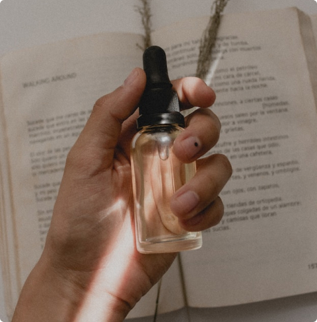 Person holding a fragrance oil bottle